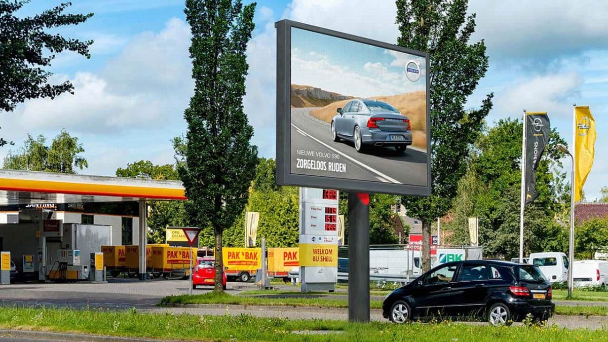 Grosse LED-Werbewand an einer Tankstelle mit Autowerbung